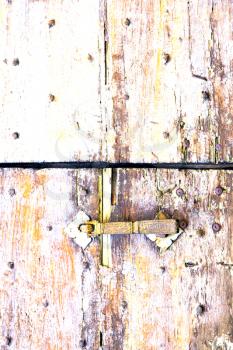 abstract   rusty brass brown knocker in a  door curch  closed wood lombardy italy  varese azzate