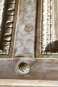 the busto arsizio abstract   rusty brass brown knocker in a  door curch  closed wood italy  lombardy   
