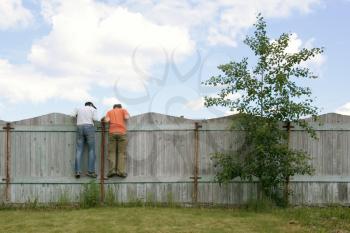 Photo of two boys on the fence looking for smth