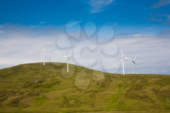 Modern windmills on a green hill