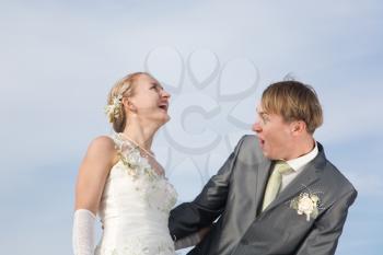 Happy bride and groom, cloudy sky background