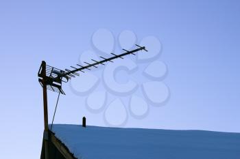 The television antenna on the snowy roof of the old house