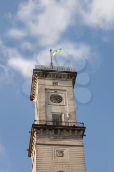 City clock tower against blue sky with clouds. Lviv, Ukraine