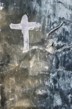 The metal surface is covered with paint layers. The Cross pictured on an old painted metal surface