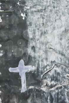 The metal surface is covered with paint layers. The Cross pictured on an old painted metal surface