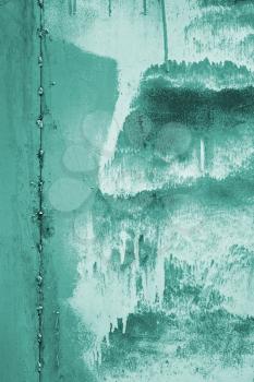 Painted vertical metal sheet surface with rusty abstract stains toned in turquoise as a texture