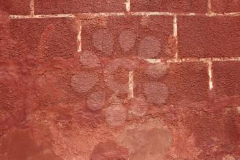 Detail of old red shelled wall with white painted rectangles