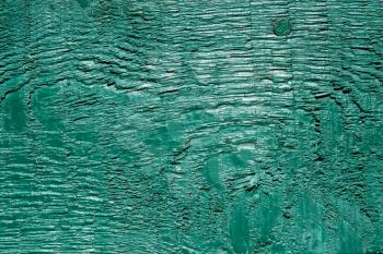 Fragment of old painted turquoise wooden board in sunlight