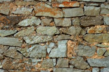 Detail of multicolor stone wall with coarse formless colored stones