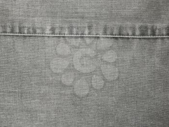 Fragment of obsolete gray fabric with seam and fine details close up