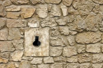 Loophole in medieval masonry stone fortress close-up in Lviv, Ukraine