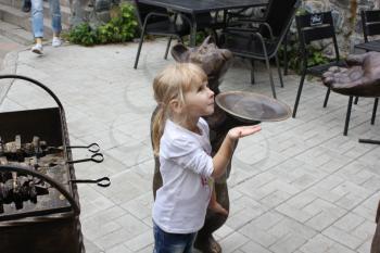 Cute little girl copies statue bear in zoo 18702