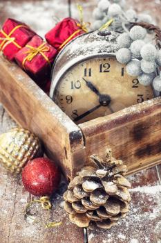 outdated watch in wooden box on the background of Christmas decorations and pine cones.Photo tinted.