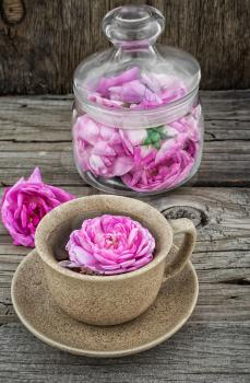 Cup with fresh fragrant herbal decoction of tea rose.The image is tinted