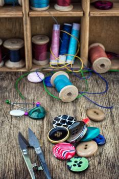 set of threads and buttons on wooden background.Selective focus