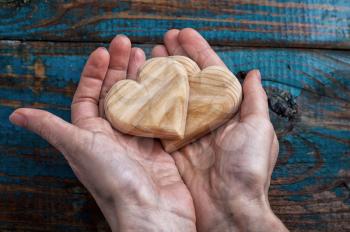 two symbolic wooden heart in your hands