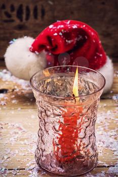 festive decoration with Christmas hat and a burning candle