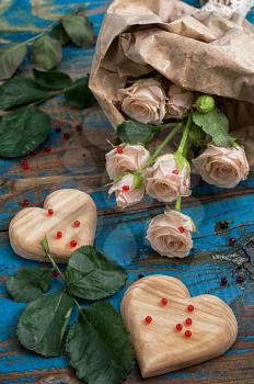 two wooden heart and bouquet of fresh cut roses