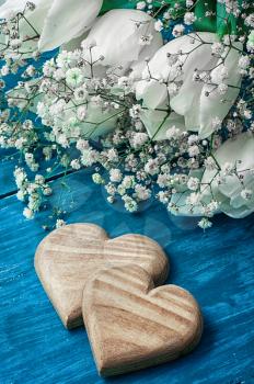 symbolic wooden heart on the background of bouquet of white roses