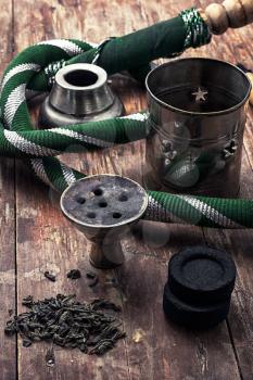 details Shisha and accessories on wooden background.image is tinted in vintage style