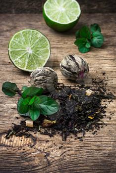 tea brew with lime and mint on wooden background in country style.Selective focus