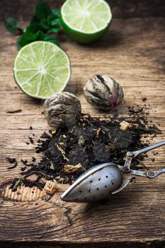 tea brew with lime and mint on wooden background in rustic style.Selective focus