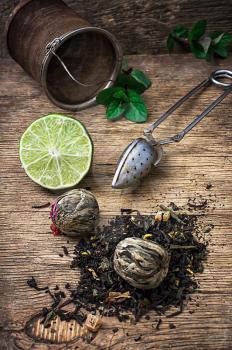 tea brew with lime and mint on wooden background in country style.Selective focus