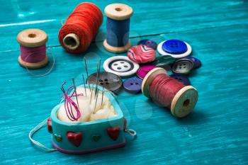 thread buttons for crafts on turquoise wooden background