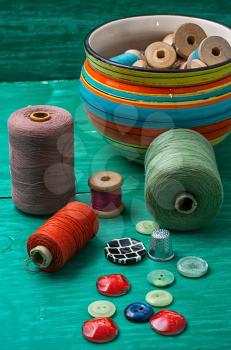 thread buttons for crafts on turquoise wooden background