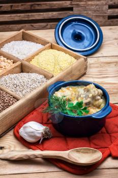 wooden box with varieties of cereals on the background of the cooked pilaf.
