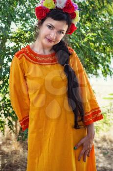 charming woman with wreath on his head on the background of nature in bright sunlight.Selective focus