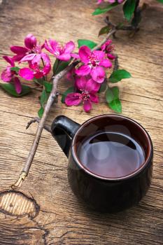 floral black tea in cup on wooden background.