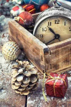 Retro alarm clock in  wooden box in the composition with Christmas decorations.