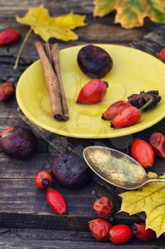Still life with yellow cup of tea,sipontum,leaves and chestnuts