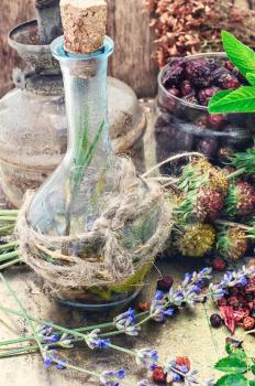 carafe of medicinal decoction on the background of medicinal herbs