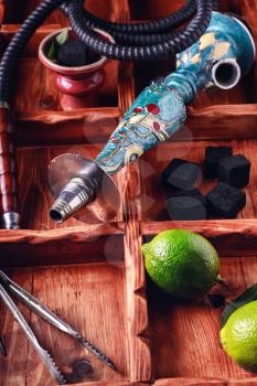 dismantled parts of the hookah in stylish wooden box with fruits lime