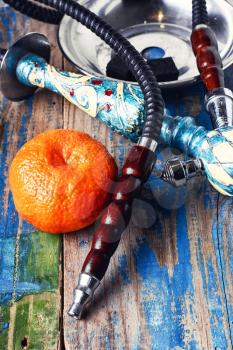 Dismantled parts of hookah on a wooden background with lime fruit