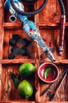 dismantled parts of the hookah in stylish wooden box with fruits lime