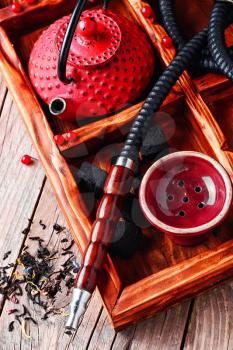 Details of smoking hookah,cast iron red teapot in wooden box