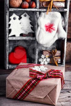 Gift boxes with bow on background of decorations with mittens and Christmas trees in the box
