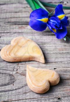 Two symbolic wooden heart on background of fresh flowers