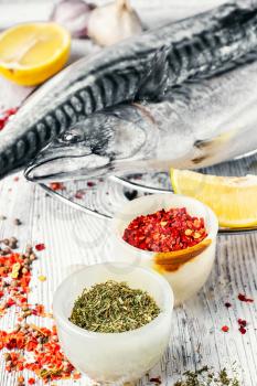 Thawed fresh fish mackerel with spices and marinade with lemon.Photograph high key