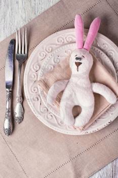 Plate,knife and fork with a toy rabbit for Easter dinner