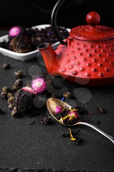 Red teapot and varieties of loose leaf and blooming tea