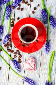 Red coffee cup on a wooden tray covered with flowers of hyacinth
