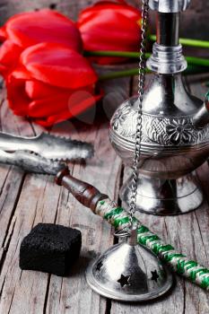 Stylish metal Arabic hookah and a bunch of tulips