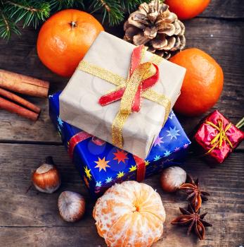 Christmas gifts,tangerines,nuts and spices on wooden background