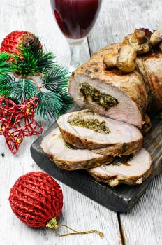 Dish of roulade of veal stuffed with mushrooms and spices and Christmas decorations
