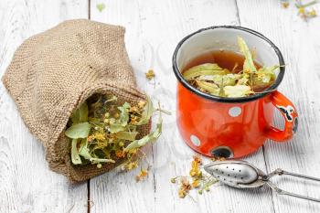 Iron mug of tea brewed with dried medicinal inflorescence of Linden