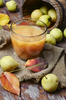 Glass cup pear juice autumn pears scattered across the table